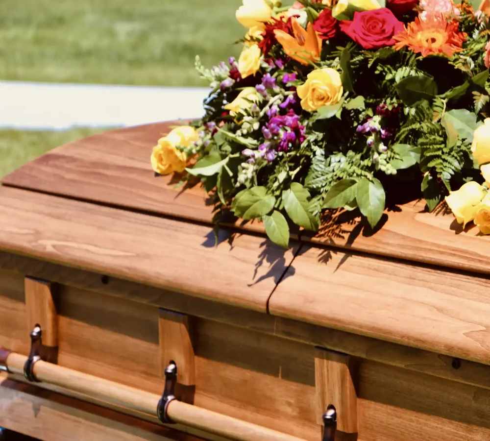 lovely-floral-arrangement-on-wood-casket-2024-12-06-10-01-35-utc